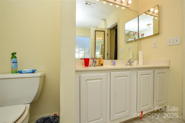 bathroom with visible vents, toilet, and vanity