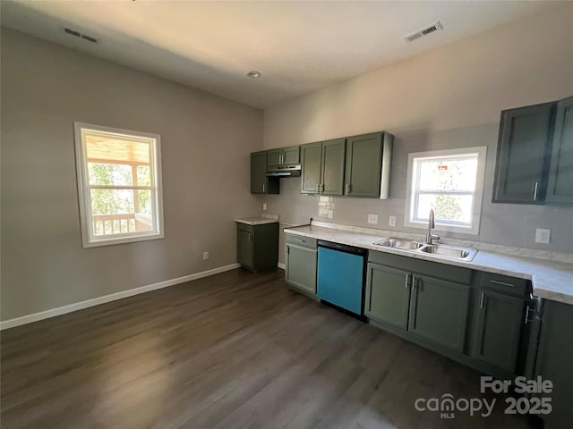 kitchen with dishwashing machine, dark wood finished floors, visible vents, a sink, and baseboards