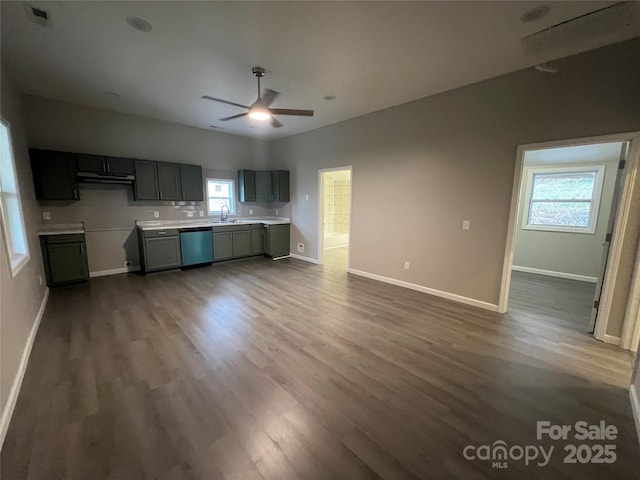 kitchen with light countertops, dark wood-type flooring, ceiling fan, dishwasher, and baseboards