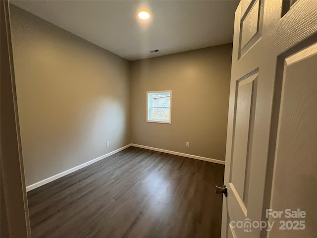 unfurnished bedroom featuring dark wood-type flooring, visible vents, and baseboards