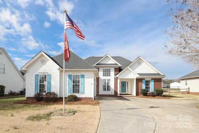 view of front of property with a shingled roof and fence