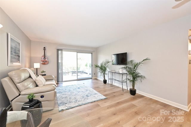 living area featuring baseboards and wood finished floors