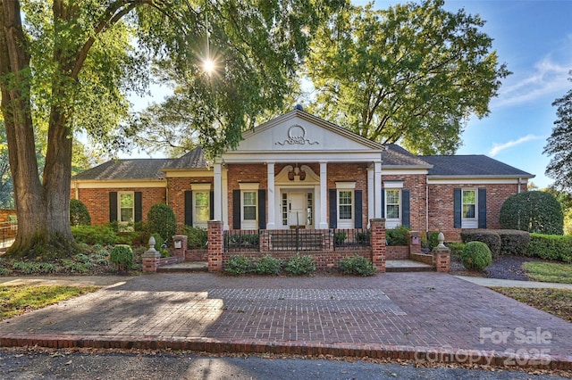 greek revival house with a porch and brick siding