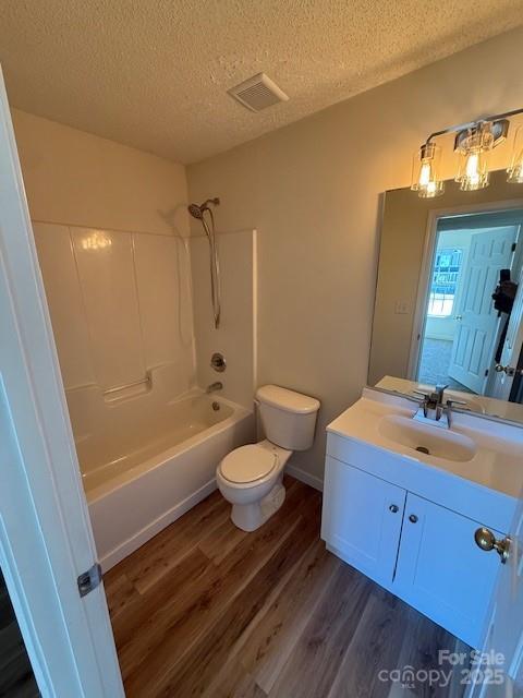 bathroom with toilet, visible vents, wood finished floors, and vanity