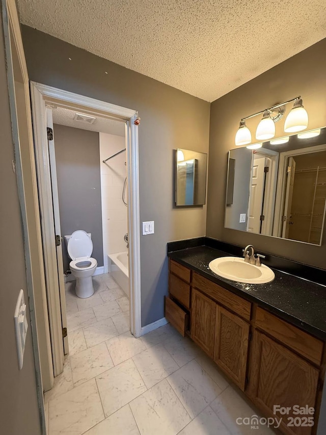 bathroom with baseboards, visible vents, toilet, a textured ceiling, and vanity