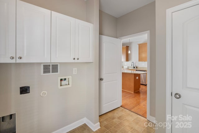 clothes washing area with hookup for an electric dryer, washer hookup, a sink, visible vents, and cabinet space