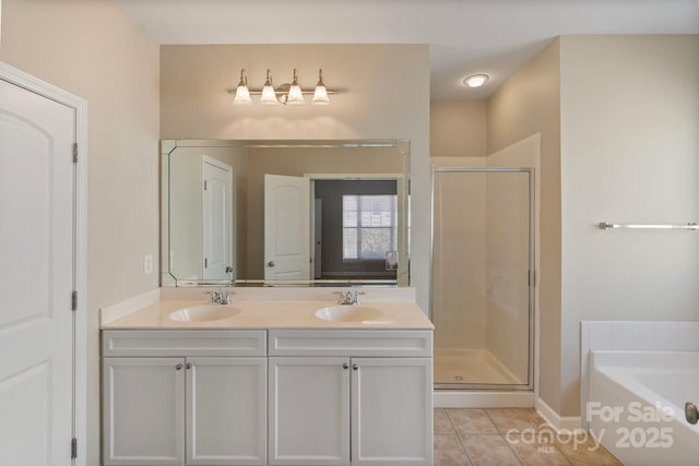 bathroom featuring a bath, a stall shower, a sink, and tile patterned floors