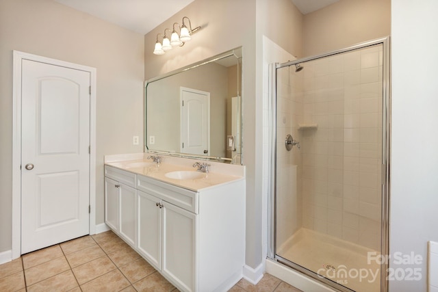 full bath with a stall shower, tile patterned flooring, and a sink