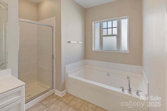 full bathroom with a garden tub, a stall shower, tile patterned flooring, and vanity