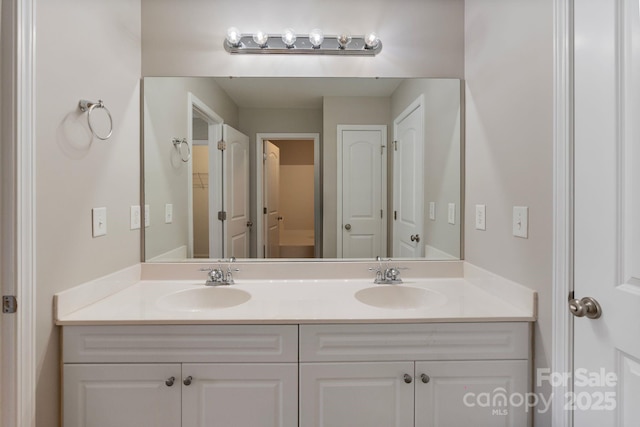 bathroom featuring double vanity, a closet, and a sink