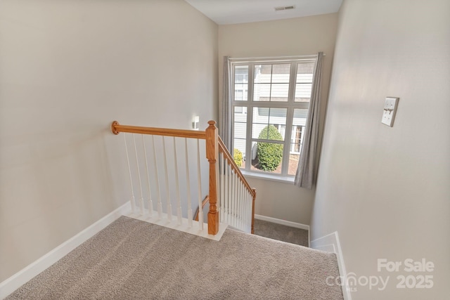 stairway featuring carpet floors, visible vents, and baseboards