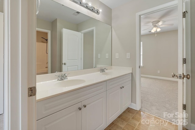 bathroom featuring double vanity, a sink, a ceiling fan, and baseboards