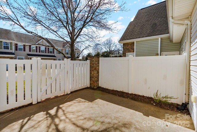 view of yard with a residential view, a gate, fence, and a patio