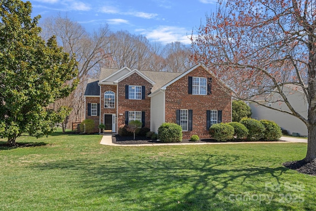 view of front facade with brick siding and a front yard