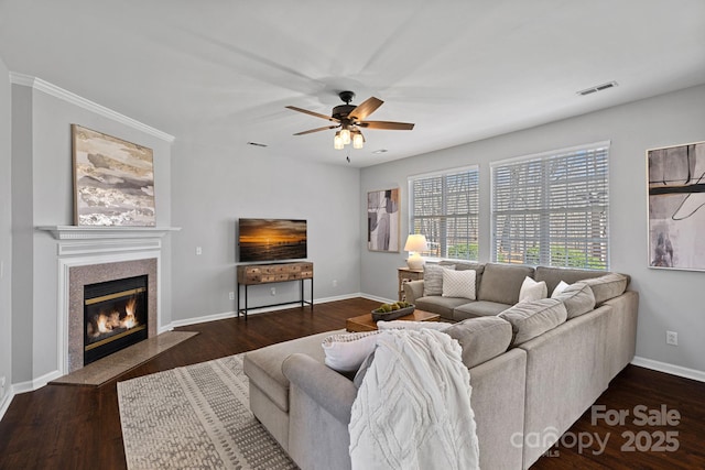 living area featuring visible vents, baseboards, a fireplace, ceiling fan, and dark wood-type flooring