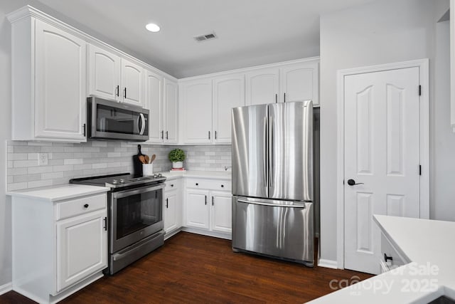 kitchen with visible vents, dark wood finished floors, appliances with stainless steel finishes, white cabinets, and decorative backsplash