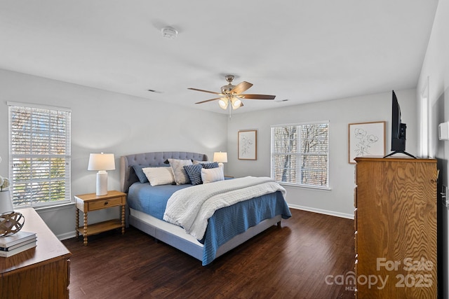 bedroom featuring multiple windows, wood finished floors, and baseboards