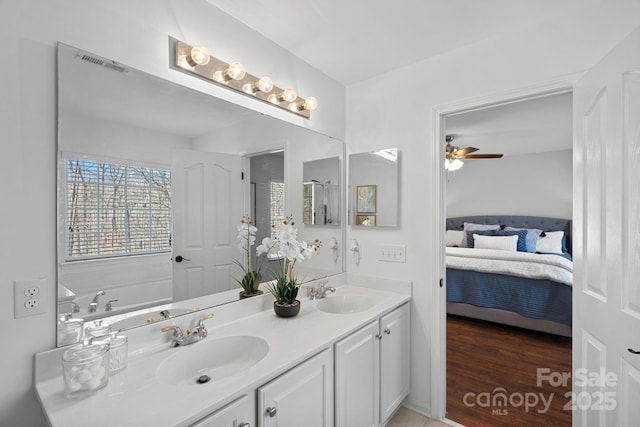 ensuite bathroom with a sink, visible vents, ensuite bath, and double vanity