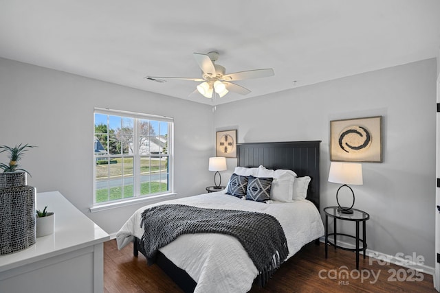 bedroom featuring dark wood finished floors, baseboards, visible vents, and ceiling fan