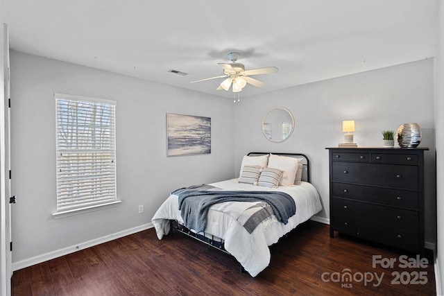 bedroom with ceiling fan, wood finished floors, visible vents, and baseboards