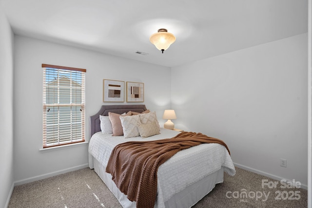 bedroom featuring visible vents, baseboards, and carpet