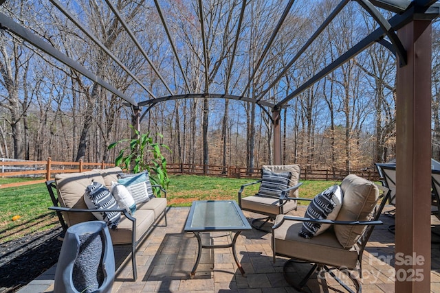 view of patio featuring outdoor lounge area, a fenced backyard, and a view of trees