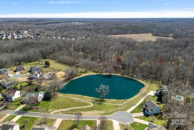 birds eye view of property featuring a wooded view and a water view