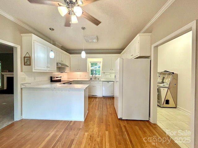 kitchen featuring ceiling fan, crown molding, a sink, a peninsula, and white appliances