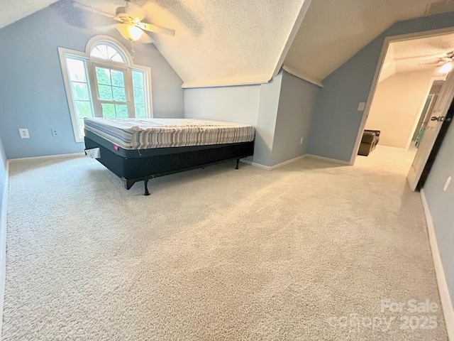 carpeted bedroom with a ceiling fan, a textured ceiling, baseboards, and lofted ceiling