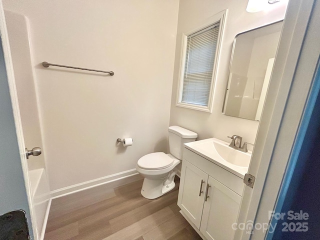 full bathroom featuring vanity, toilet, baseboards, wood finished floors, and a shower