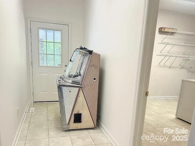 laundry area featuring light tile patterned flooring, laundry area, and baseboards