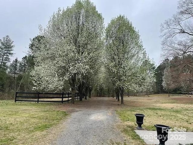 view of property's community featuring fence and a yard