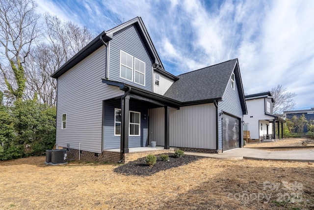 view of front of home with crawl space, concrete driveway, roof with shingles, and an attached garage