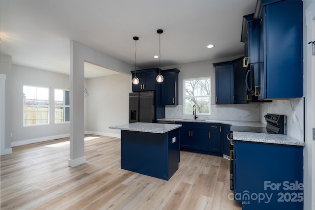 kitchen featuring range with electric cooktop, fridge with ice dispenser, blue cabinetry, backsplash, and a center island