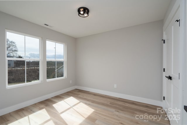 unfurnished bedroom with a closet, visible vents, light wood-style flooring, and baseboards