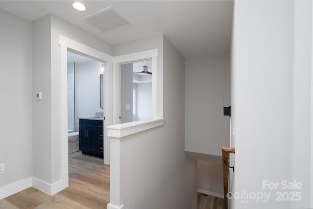 corridor featuring recessed lighting, visible vents, an upstairs landing, light wood-type flooring, and baseboards