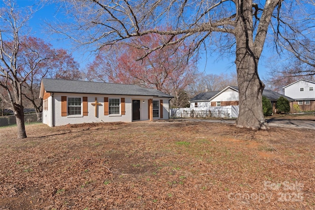 view of front facade featuring brick siding and fence