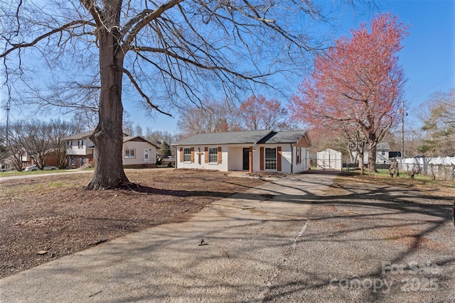 view of front of house with aphalt driveway and fence