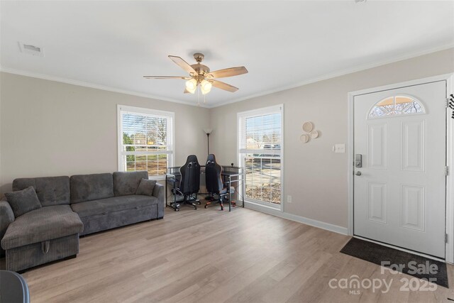 entrance foyer featuring visible vents, light wood-style floors, a healthy amount of sunlight, and crown molding