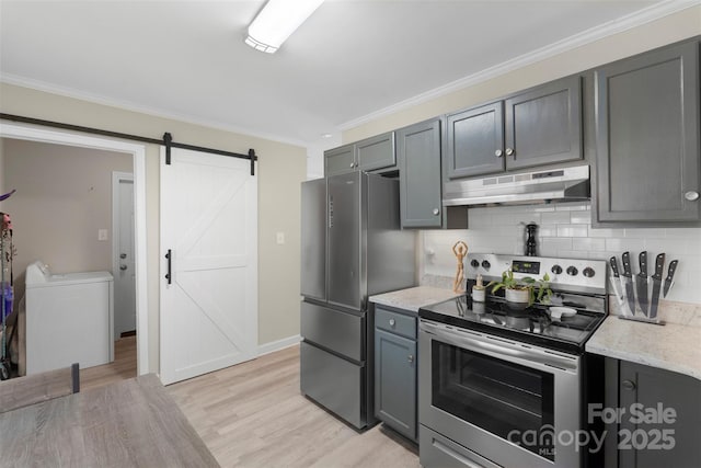 kitchen featuring stainless steel appliances, decorative backsplash, light wood-style floors, under cabinet range hood, and a barn door