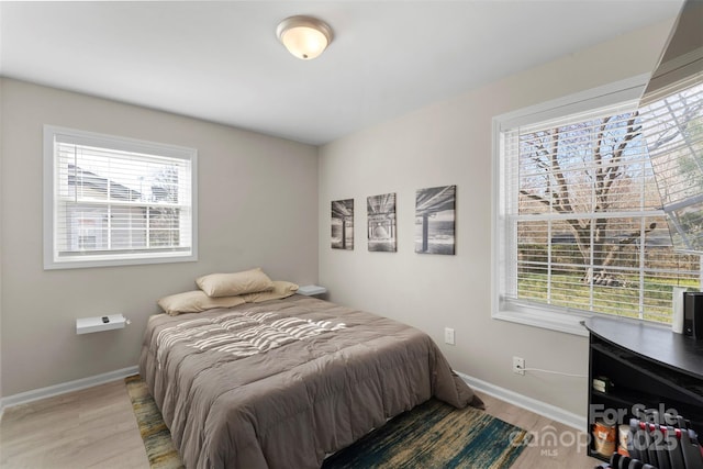 bedroom with baseboards and light wood-type flooring