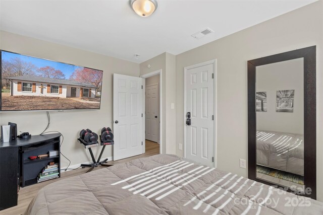 bedroom with visible vents and wood finished floors