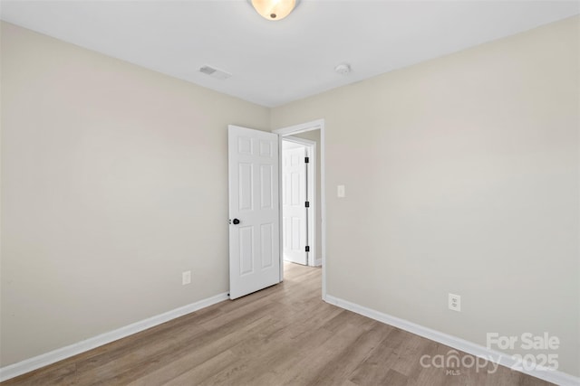 unfurnished room featuring visible vents, baseboards, and light wood-style floors