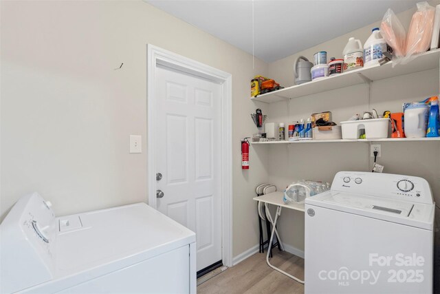 clothes washing area with baseboards, separate washer and dryer, laundry area, and light wood finished floors