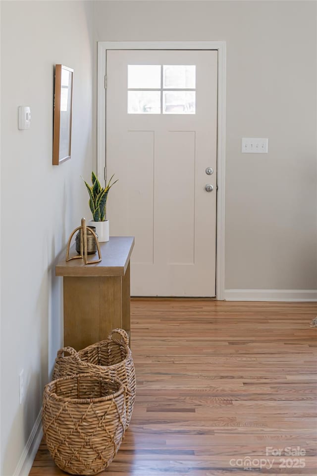 foyer entrance featuring light wood-style flooring and baseboards