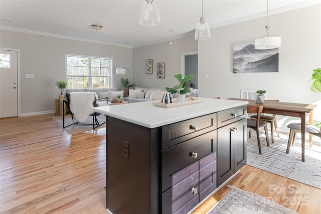 kitchen featuring ornamental molding, light countertops, light wood-style floors, and a healthy amount of sunlight