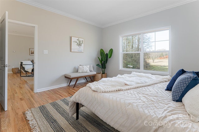 bedroom with crown molding, light wood-style flooring, and baseboards