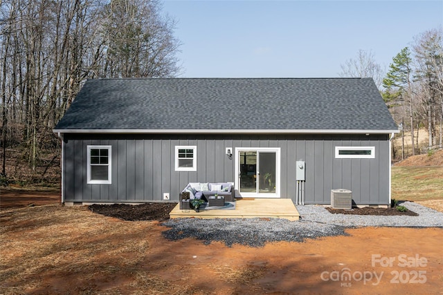 rear view of house featuring a shingled roof, cooling unit, outdoor lounge area, and board and batten siding