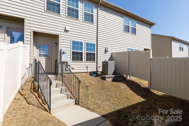 property entrance with fence and central AC unit