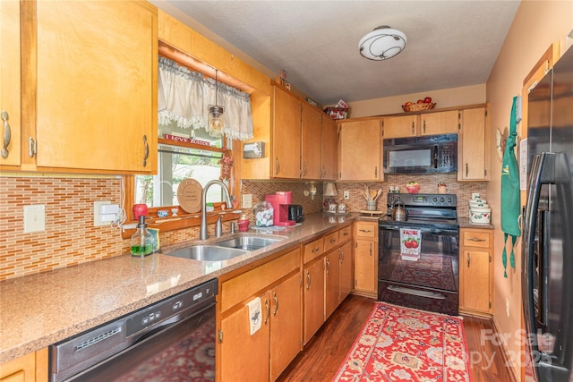 kitchen with dark wood-type flooring, a sink, backsplash, and black appliances